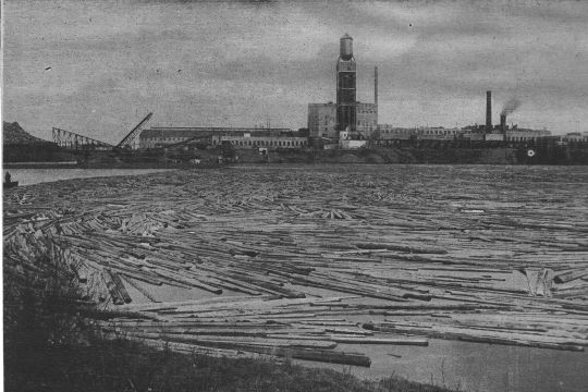 Foto Schwimmende Absperrung in einem Gewässer vor einer Fabrik